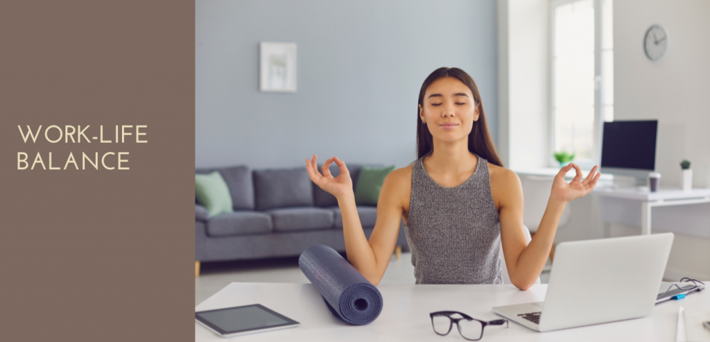 Donna che pratica yoga in casa seduta con le gambe incrociate, in posizione di meditazione, con tappetino e accessori fitness sul tavolo vicino, ambiente luminoso e rilassante